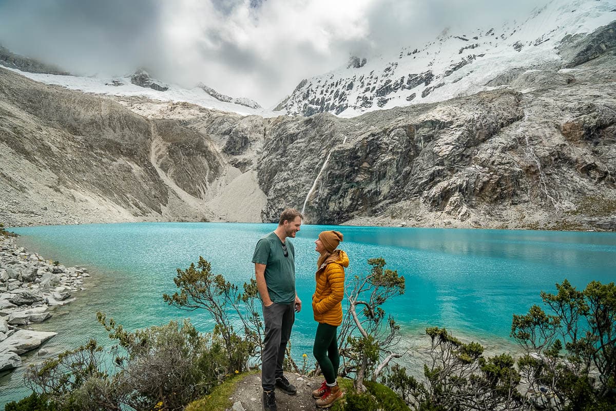 Couple smiling at each other in front of Laguna 69 in Juarez, Peru