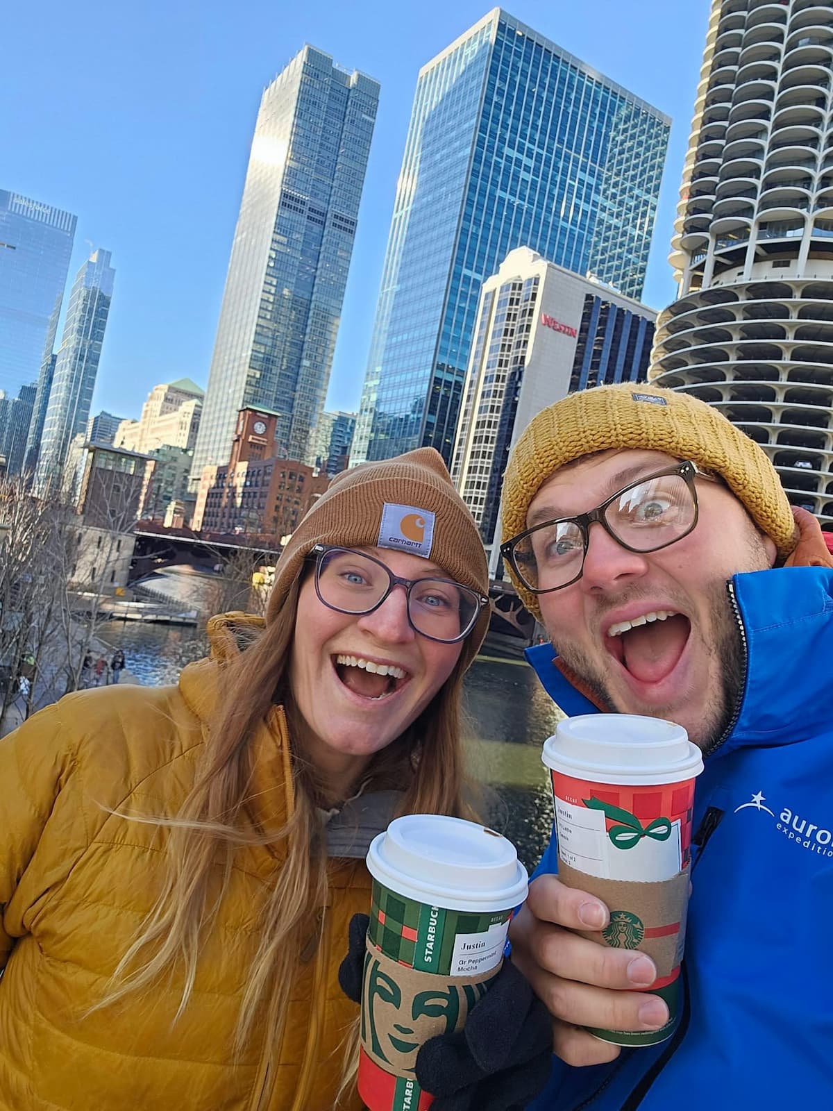 Couple holding holiday Starbucks cups along the Chicago River in Chicago, Illinois