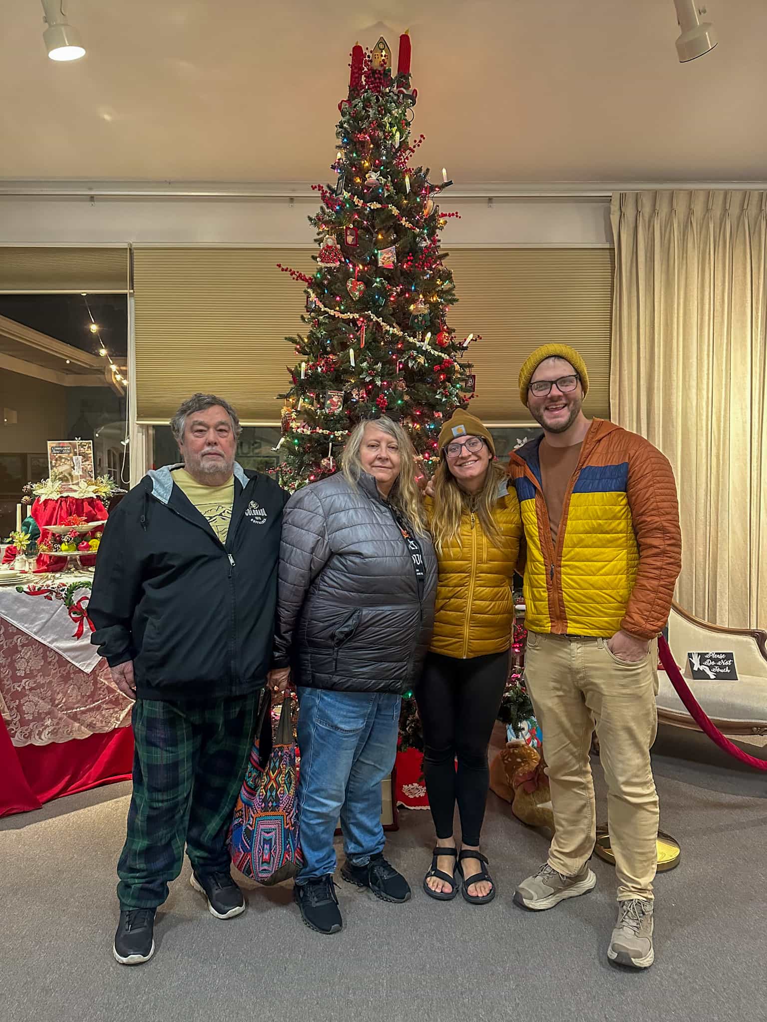 Family smiling in front of a Christmas tree