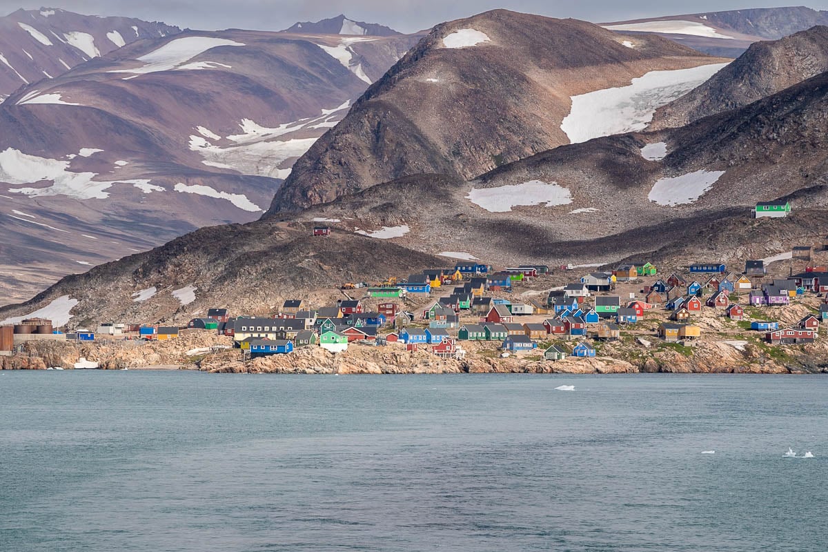 Colorful buildings on a Rocky Mountain slope on the Scoresby Sund at Ittoqqortoormiit, Greenland