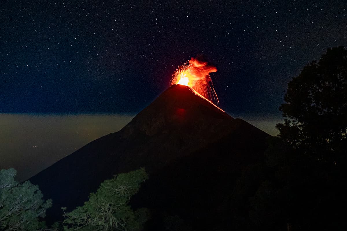 Fuego Volcano erupting with lava with stars in the night sky above along the Acatenango Hike in Guatemala
