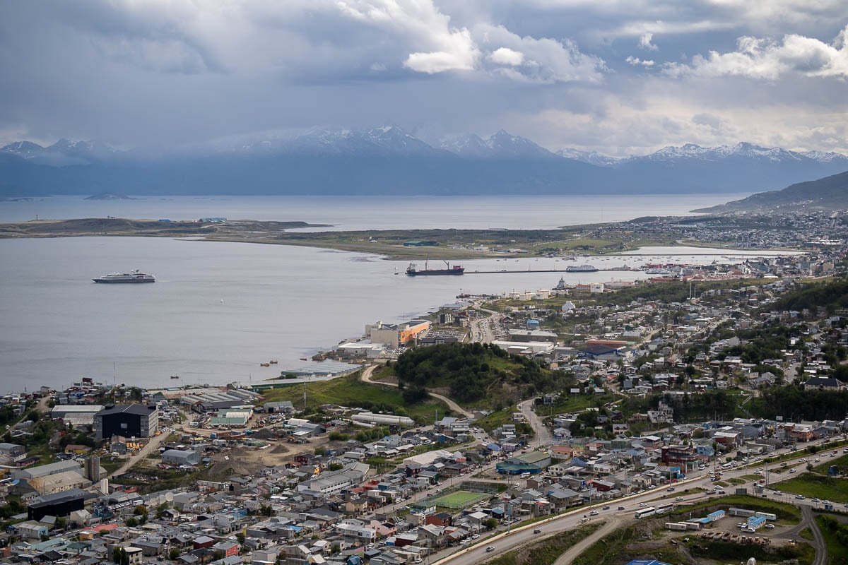 View of the town of Ushuaia, Argentina, with cruise ships leaving from the port and mountains in the background