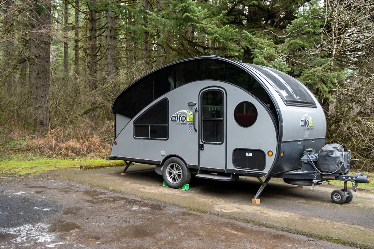 Safari Condo Alto R1723 on an asphalt campsite with stabilizing jacks resting on wooden blocks