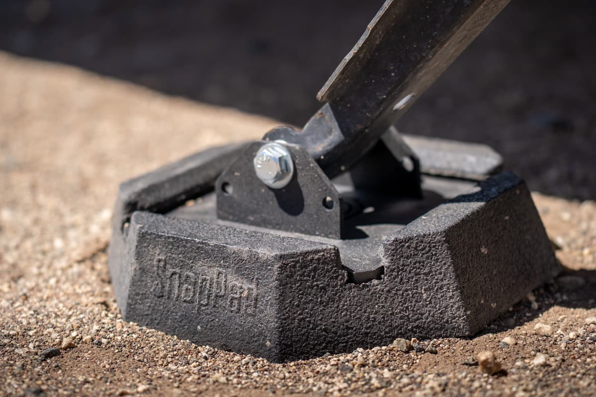 SnapPad RV jack pad attached on a stabilizing jack on a sandy surface