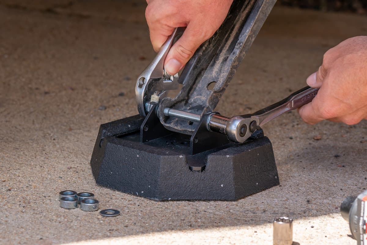 Man attaching a SnapPad RV jack pad to a stabilizing jack on a sandy surface