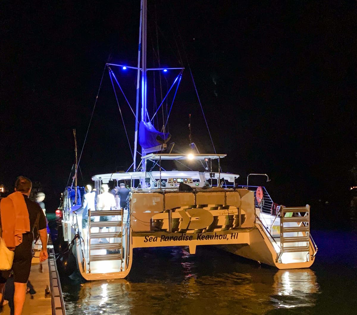 People boarding a catamaran owned by Sea Paradise for a manta ray snorkeling tour at night on the Big Island of Hawaii