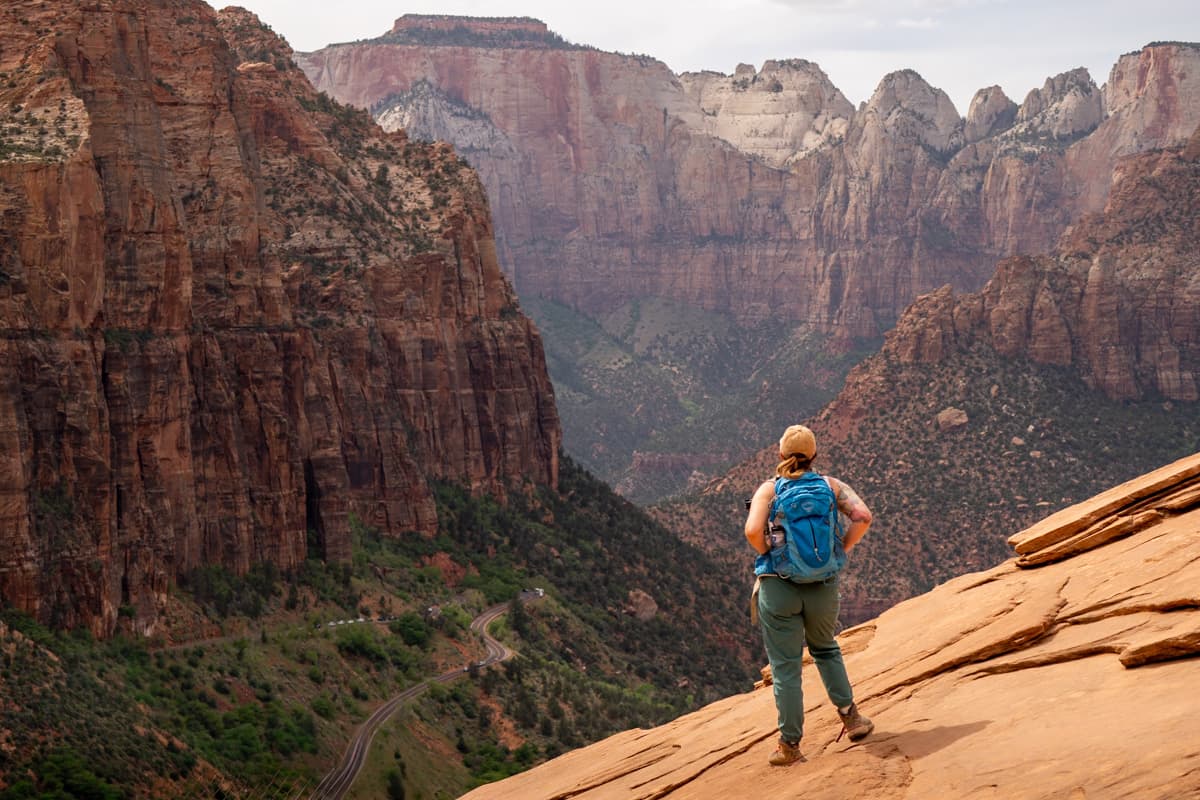 Woman standing at the viewpoint for Canyon Overlook Trail in Zion National Park