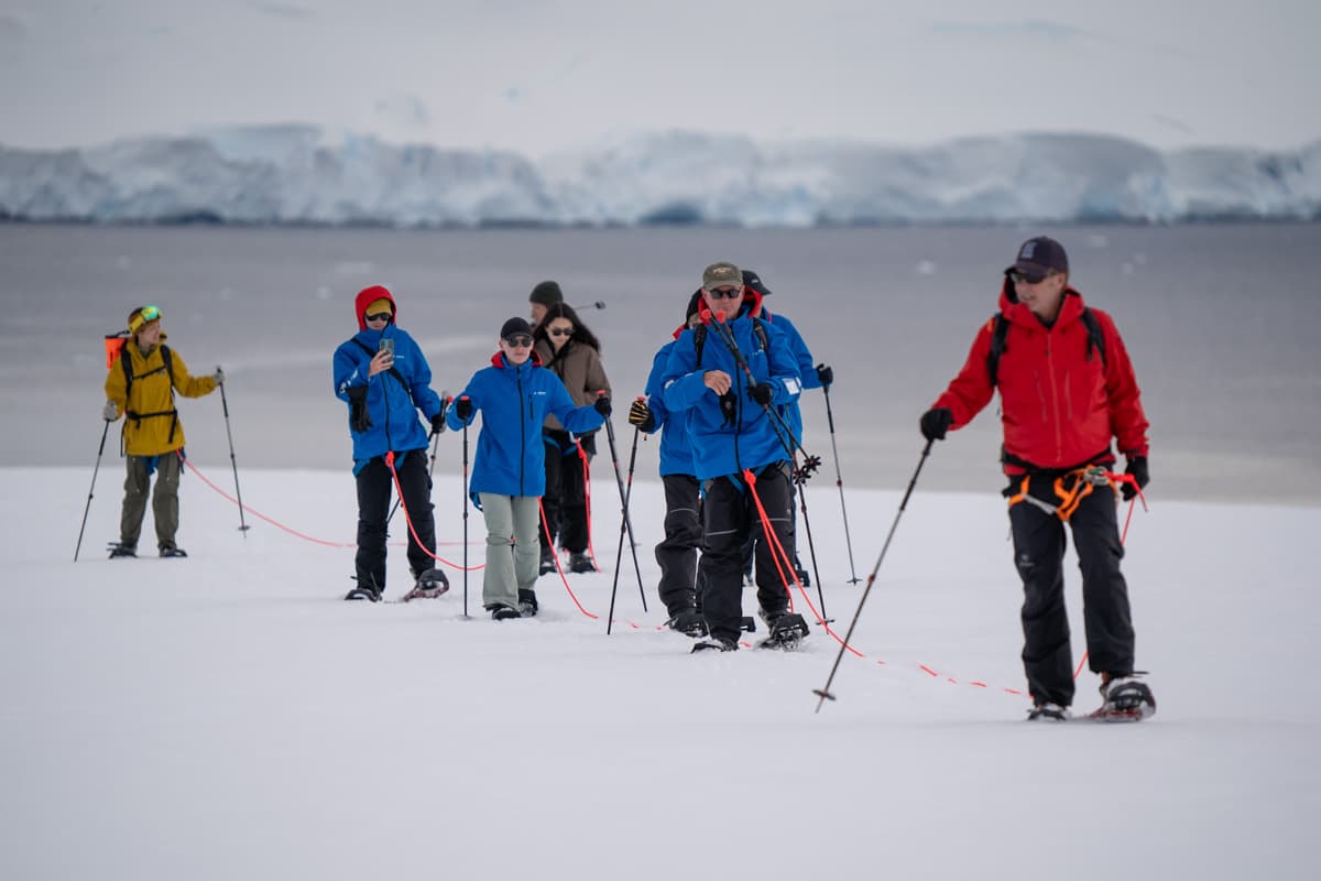 Guide leading snowshoers across a hill in Antarctica