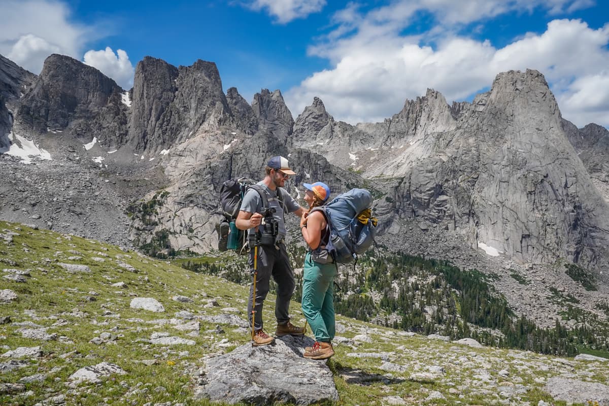 Couple standing on a rock with the Cirque of the Towers in the background in the Wind River range in Wyoming