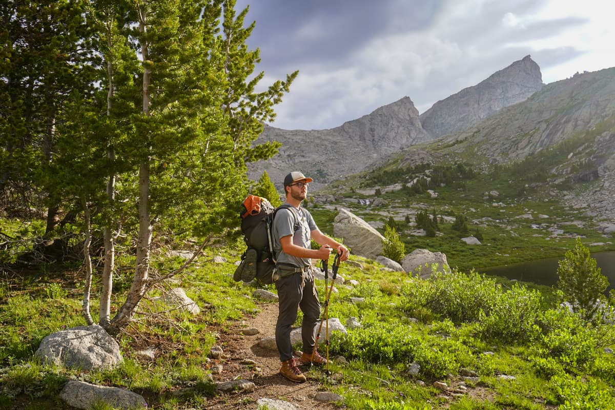 Man standing on the Cirque of the Towers trail with rugged mountains in the background in the Wind River mountain range in Wyoming