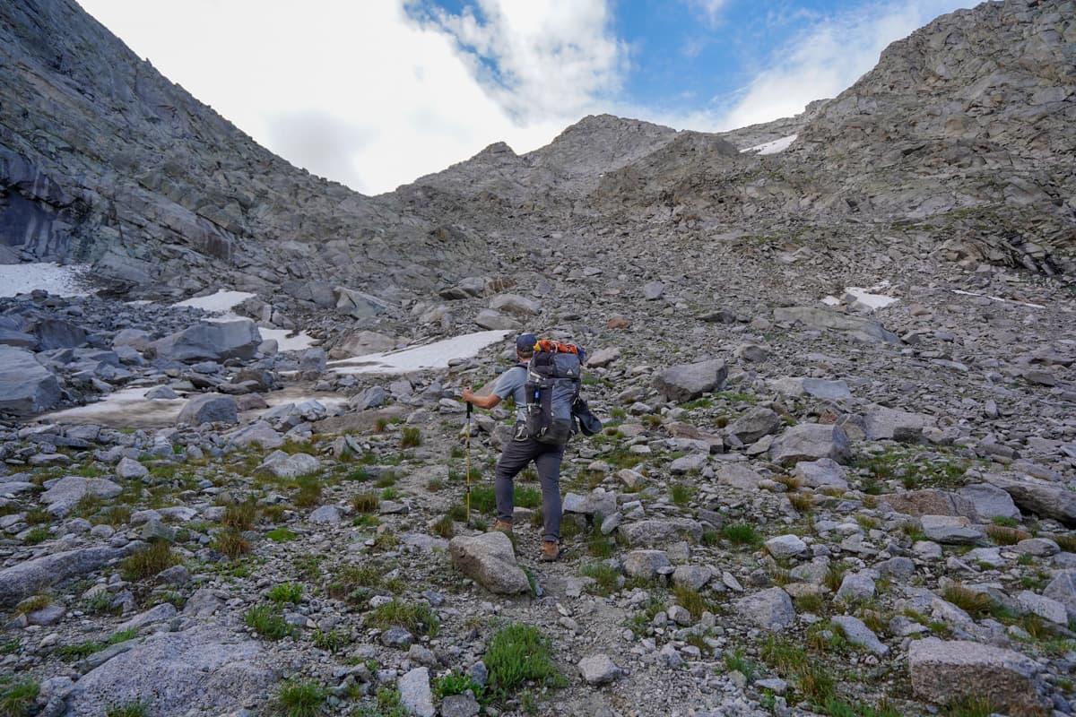Man climbing up a scree field at Texas Pass along the Cirque of the Towers trail in the Wind River range of Wyoming