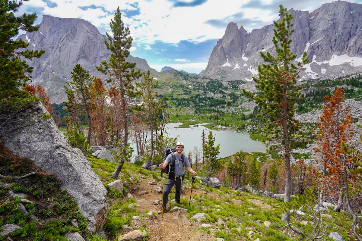 Man standing on the Cirque of the Towers trail Lonesome Lake and mountains in the background in the Wind River range in Wyoming