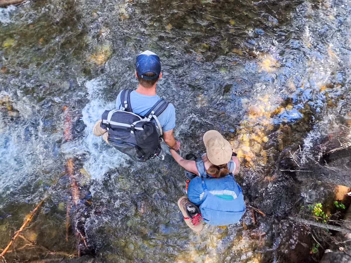 Couple crossing Conundrum Creek along the Conundrum Hot Springs Trail in Maroon Bells-Snowmass Wilderness in Aspen, Colorado