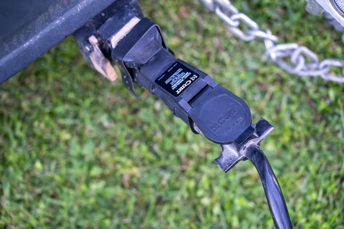 Curt Echo Wireless Brake Controller on the bumper of an SUV with a trailer's seven pin connector plugged in