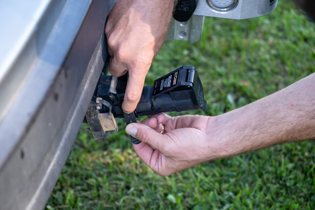 Man plugging in a Curt Echo wireless brake controller in the back of his SUV