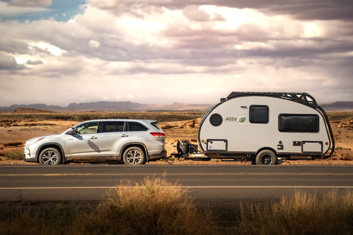 Highlander Hybrid SUV pulling a Safari Condo Alto F1743 Expedition on a cloudy day in the desert