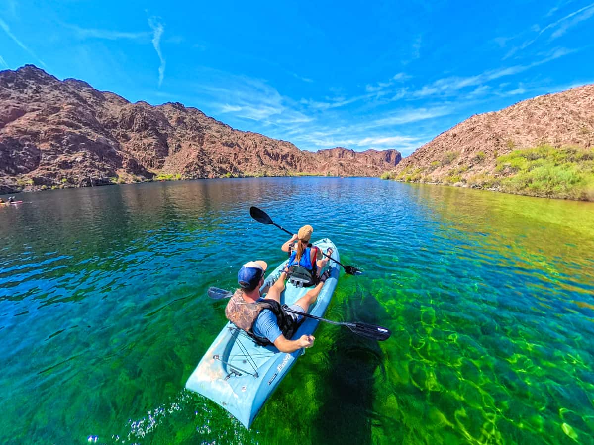 Couple kayaking down the Colorado River with canyon formations in the background in Lake Mead National Recreation Area in Willow, Arizona