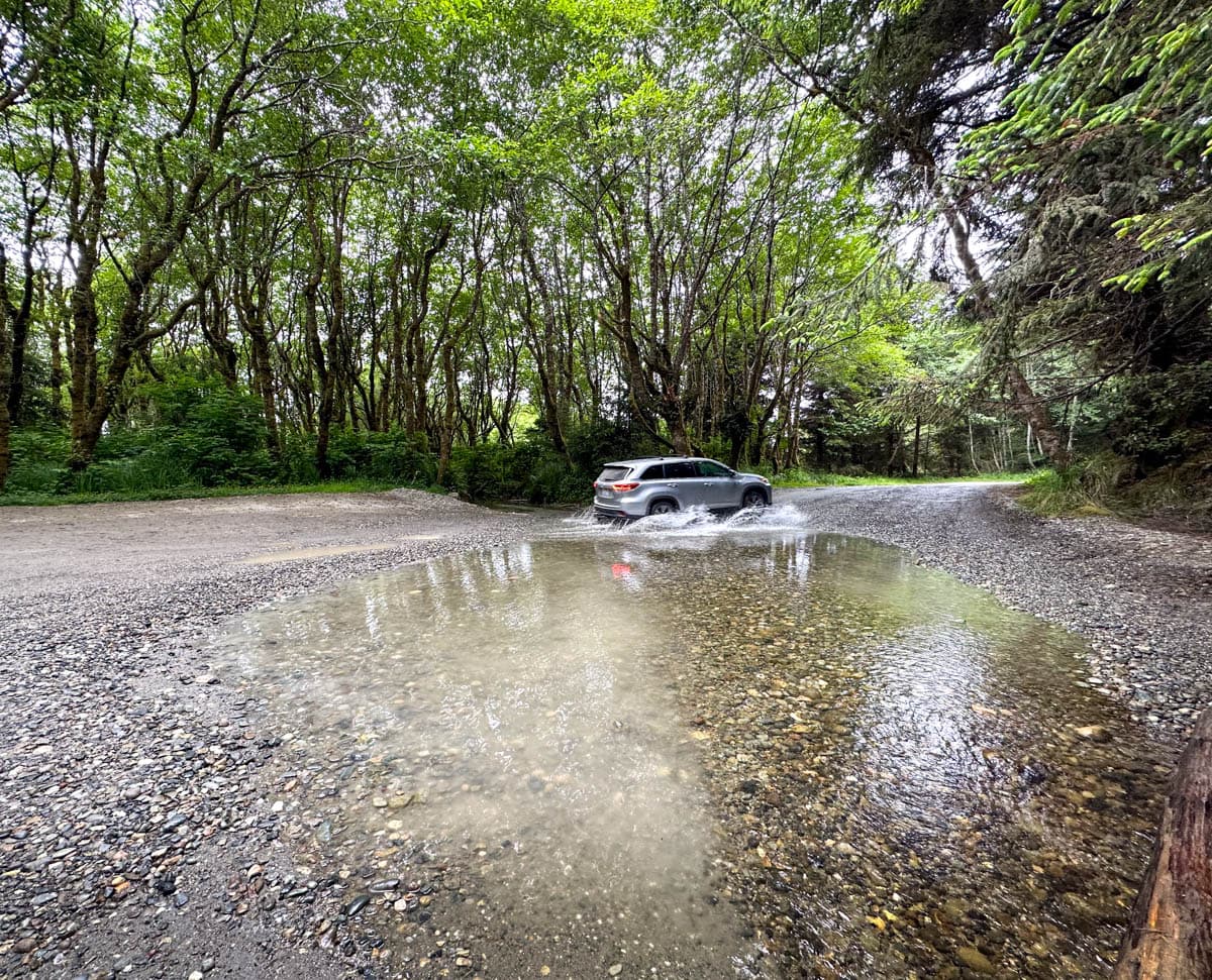 SUV crossing a stream along Davison Road to the trailhead for Fern Canyon trail in the Redwoods National and State Parks