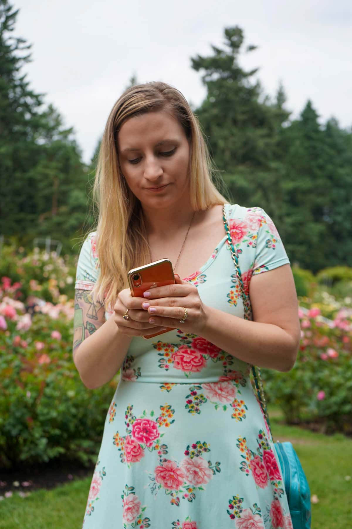 Woman looking at a cell phone in a rose garden