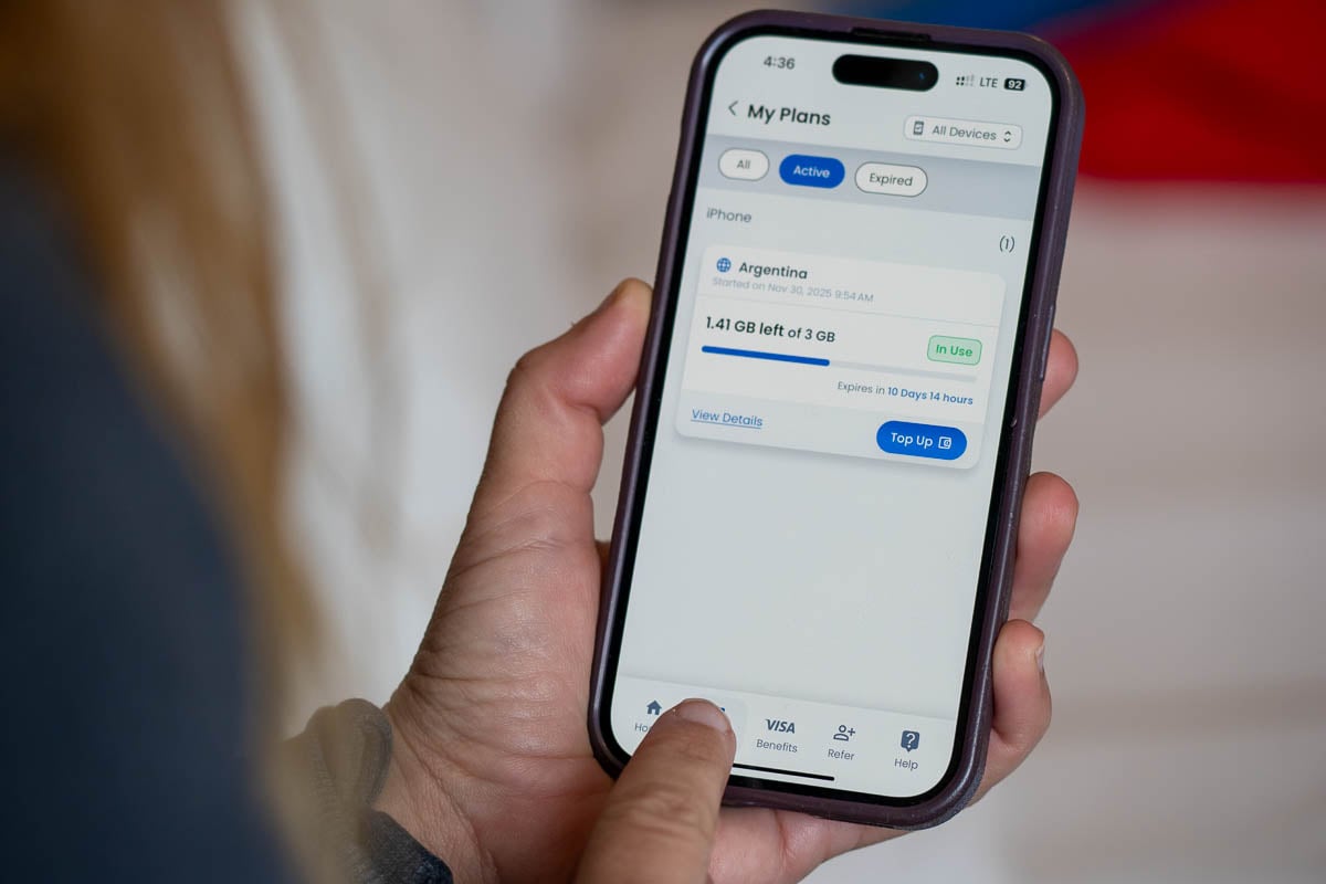 Woman looking at a cell phone with the data left on a GigSky eSIM