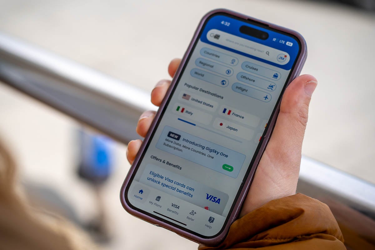 Woman holding a cell phone with GigSky app