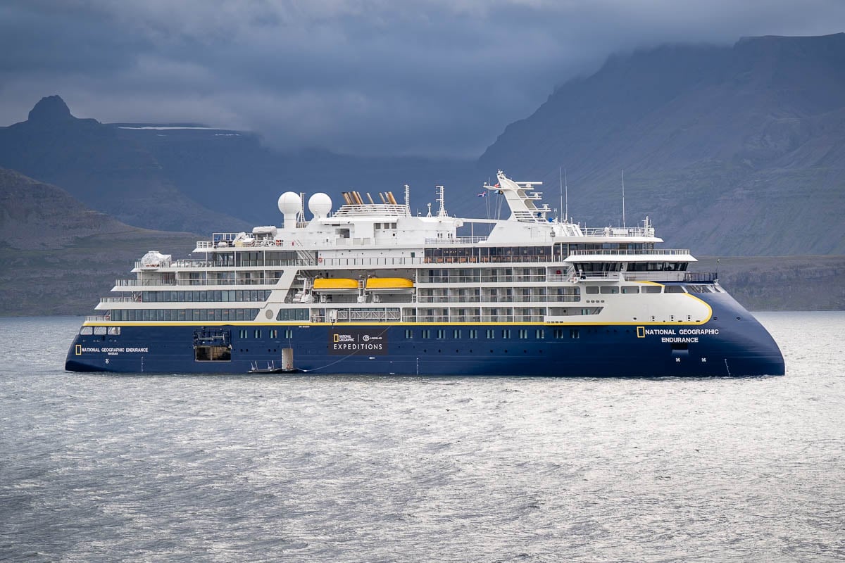 National Geographic Endurance floating in front of green cliffs in Vigur Island in the Westfjords of Iceland