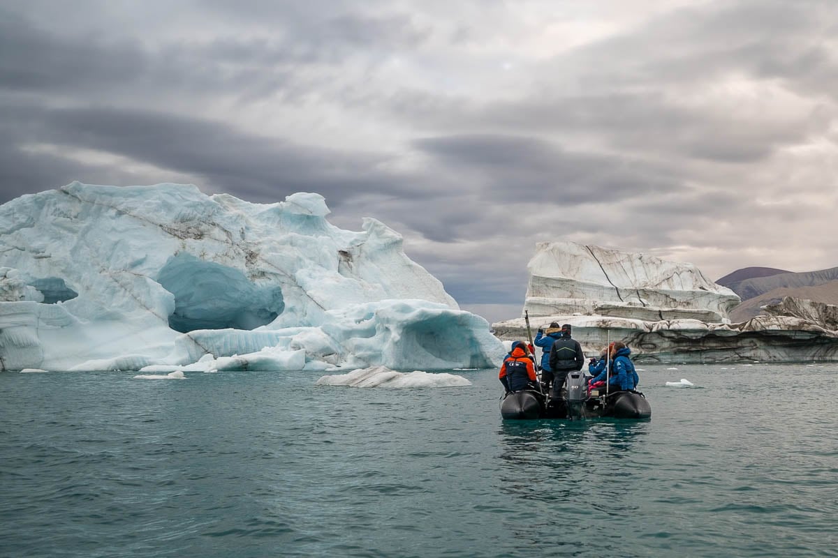 Zodiac boat with an expedition guide on National Geographic-Lindblad Expeditions with icebergs in the background in Greenland