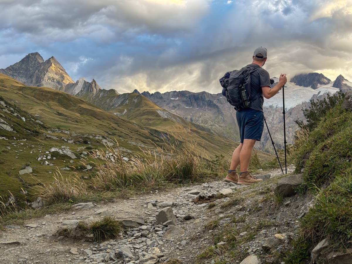 Man climbing up a rocky hill in the Vallée des Glaciers, France along the Tour du Mont Blanc