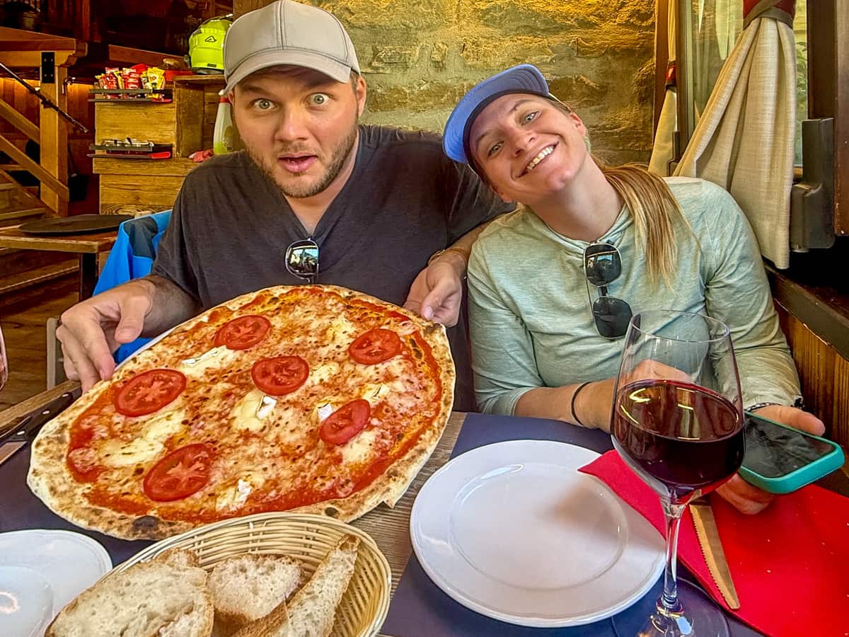 Couple with pizza and a glass of wine at a pizzeria in Courmayeur, Italy