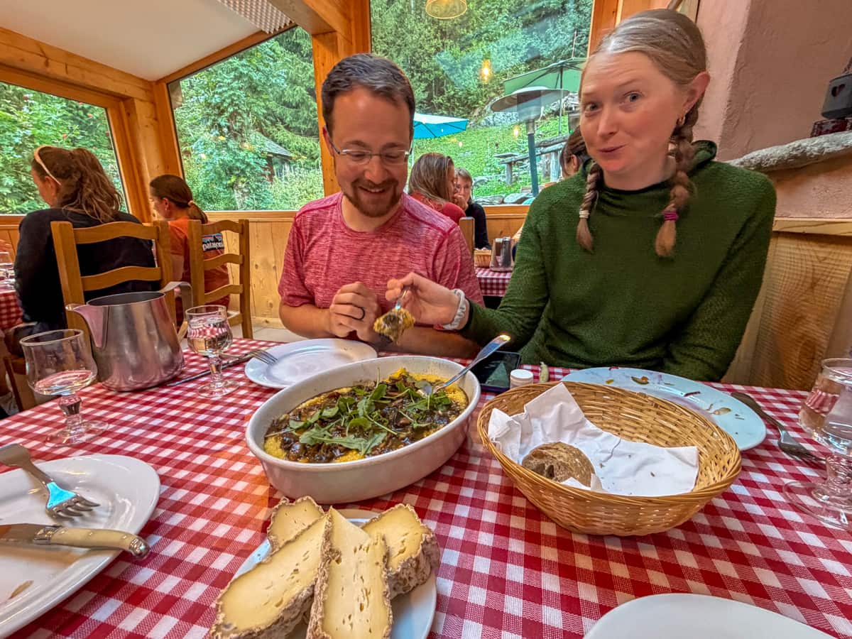 Couple eating a polenta dish at Gîte Le Moulin in Montroc, France along the Tour du Mont Blanc