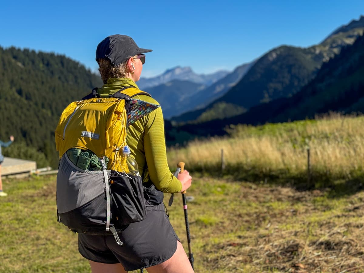 Woman standing on a path with the French Alps in the background near Les Chapieux, France along the Tour du Mont Blanc