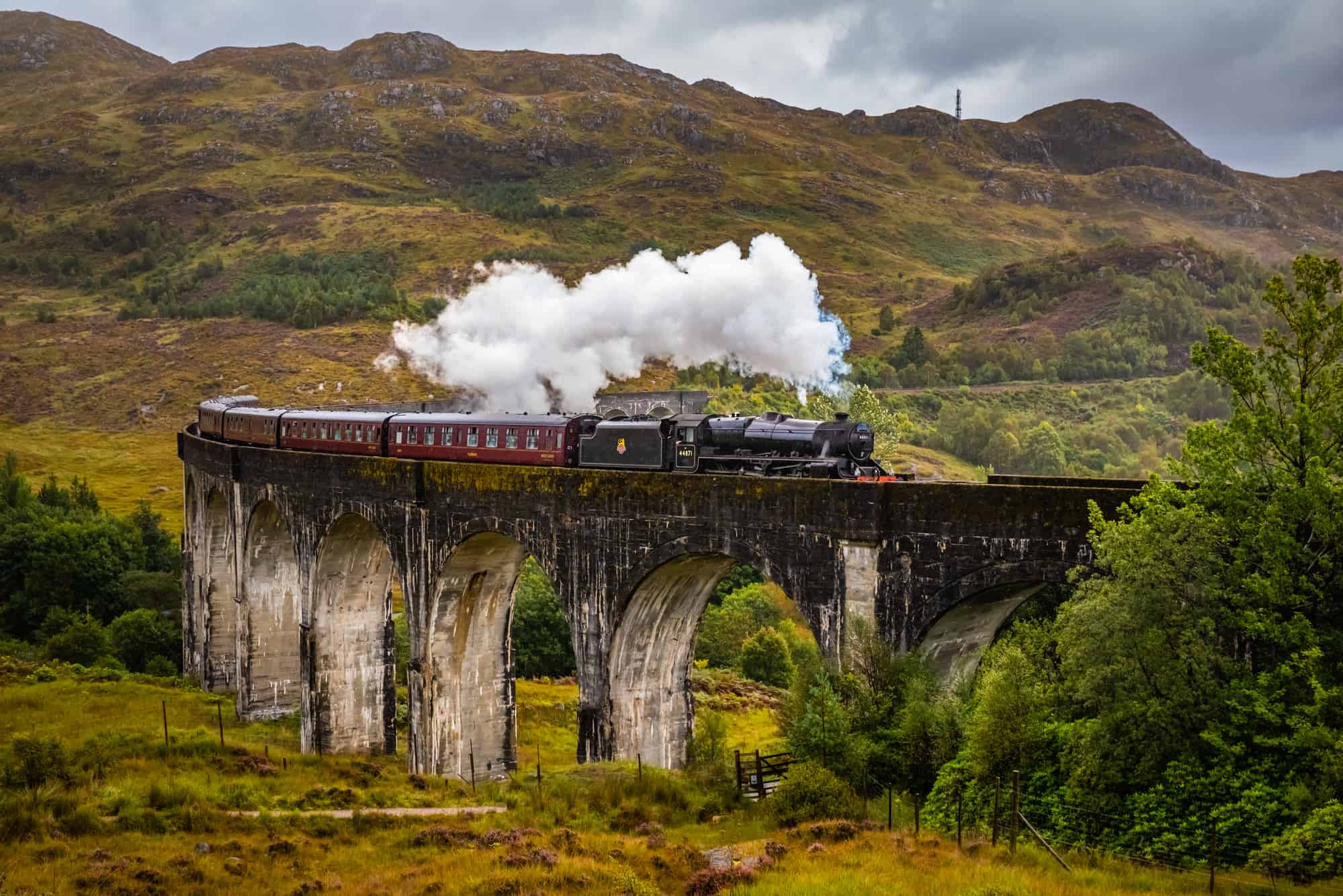 Hogwarts Express train crossing over the Glenfinnan Viaduct in Scotland