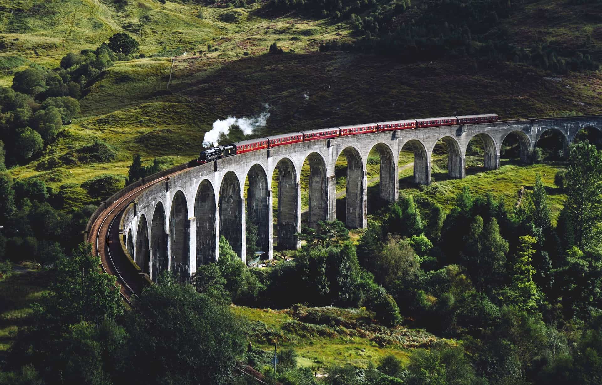 Hogwarts Express train crossing the Glenfinnan Viaduct in Scotland