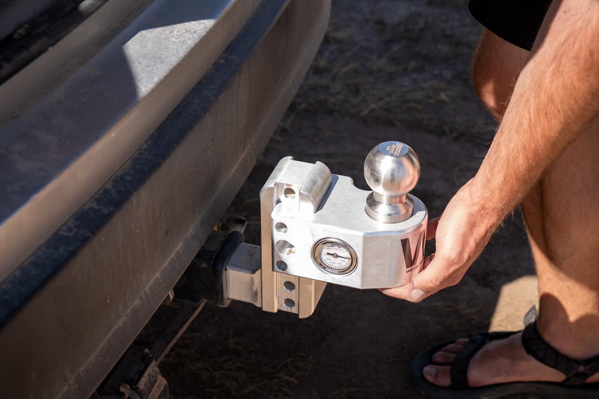 Man holding a Weigh Safe ball mount on the bumper of a Highlander Hybrid SUV