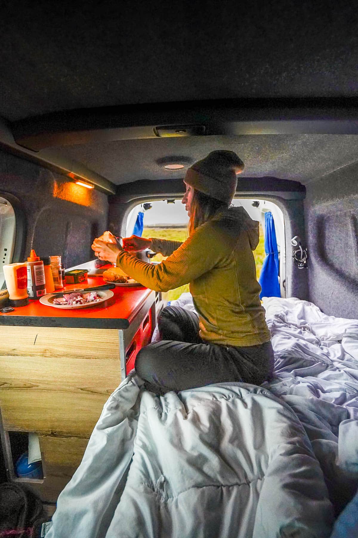 Woman cooking in a campervan at a campground in Iceland