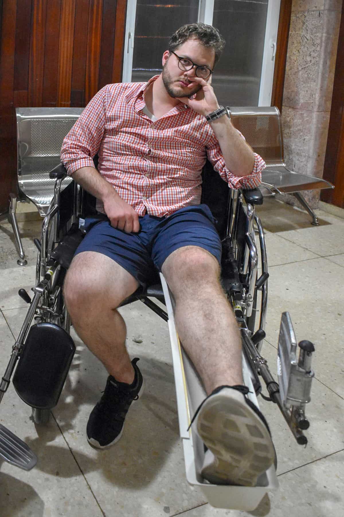 Man with a broken kneecap sitting in a wheelchair in a hospital in Cuba