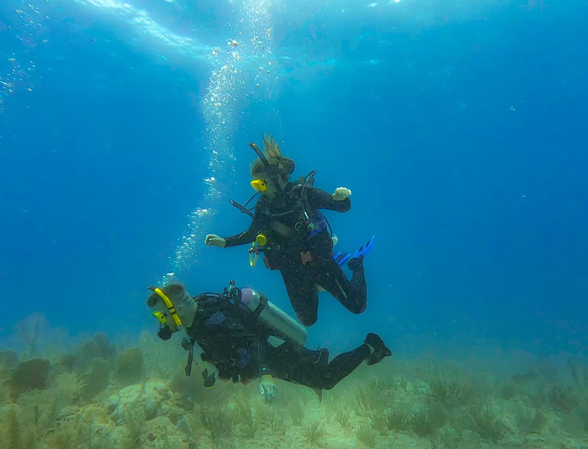 Couple scuba diving above a coral reef in Tulum, Mexico