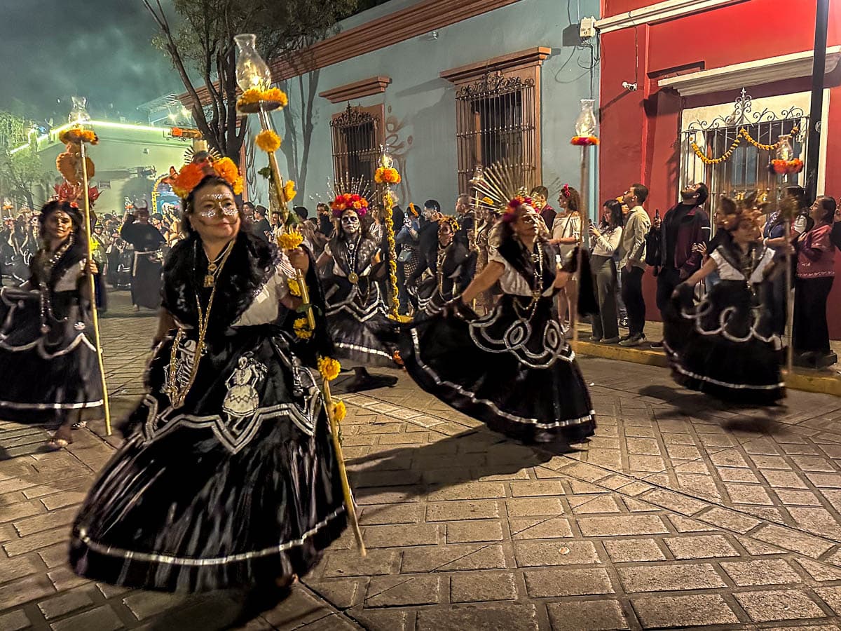 Women wearing skull makeup and costumes in a Day of the Dead parade in Oaxaca, Mexico