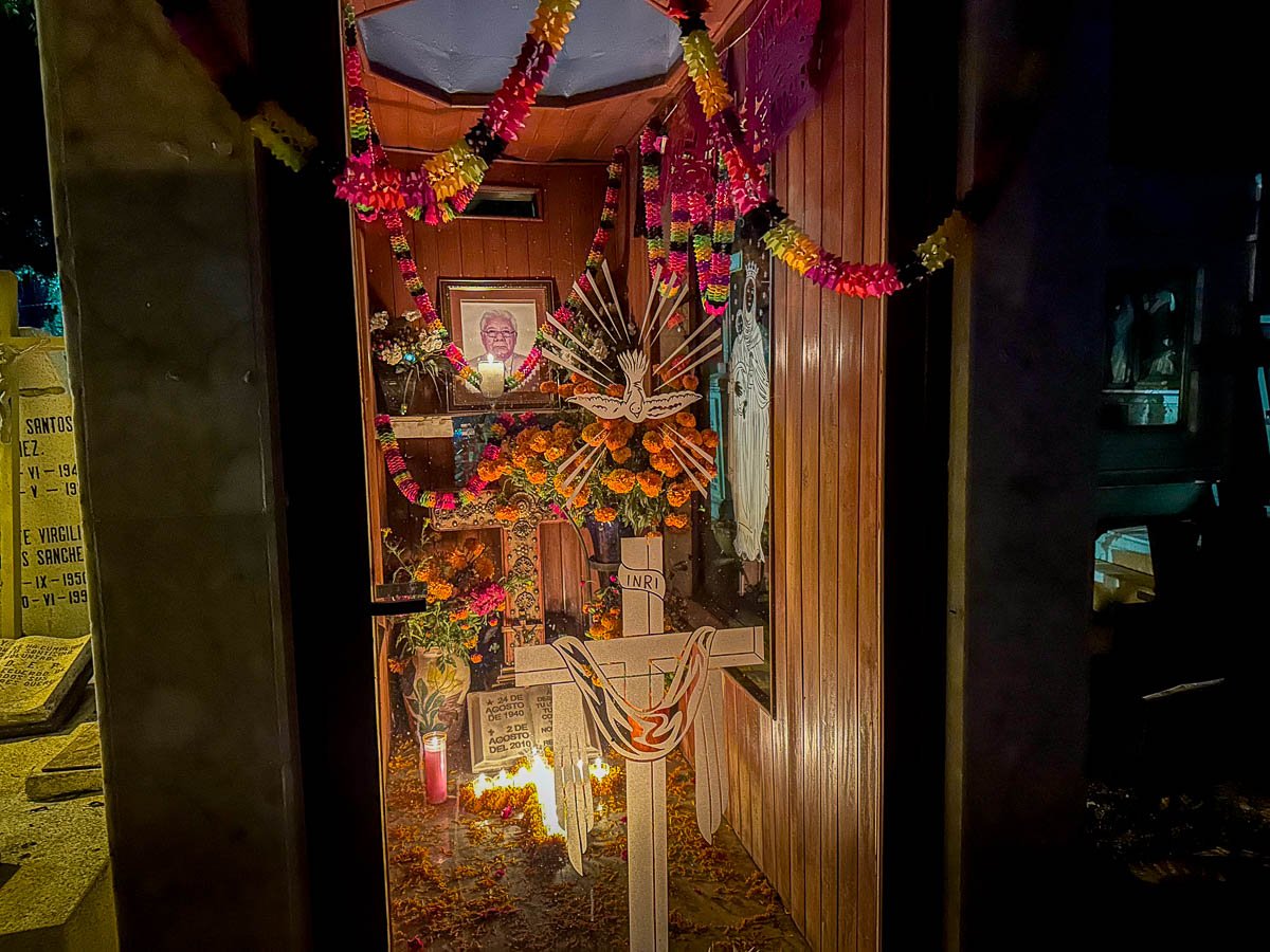 Tomb decorated with banners, candles, and marigolds in Pantheon General during Dia de Muertos in Oaxaca, Mexico