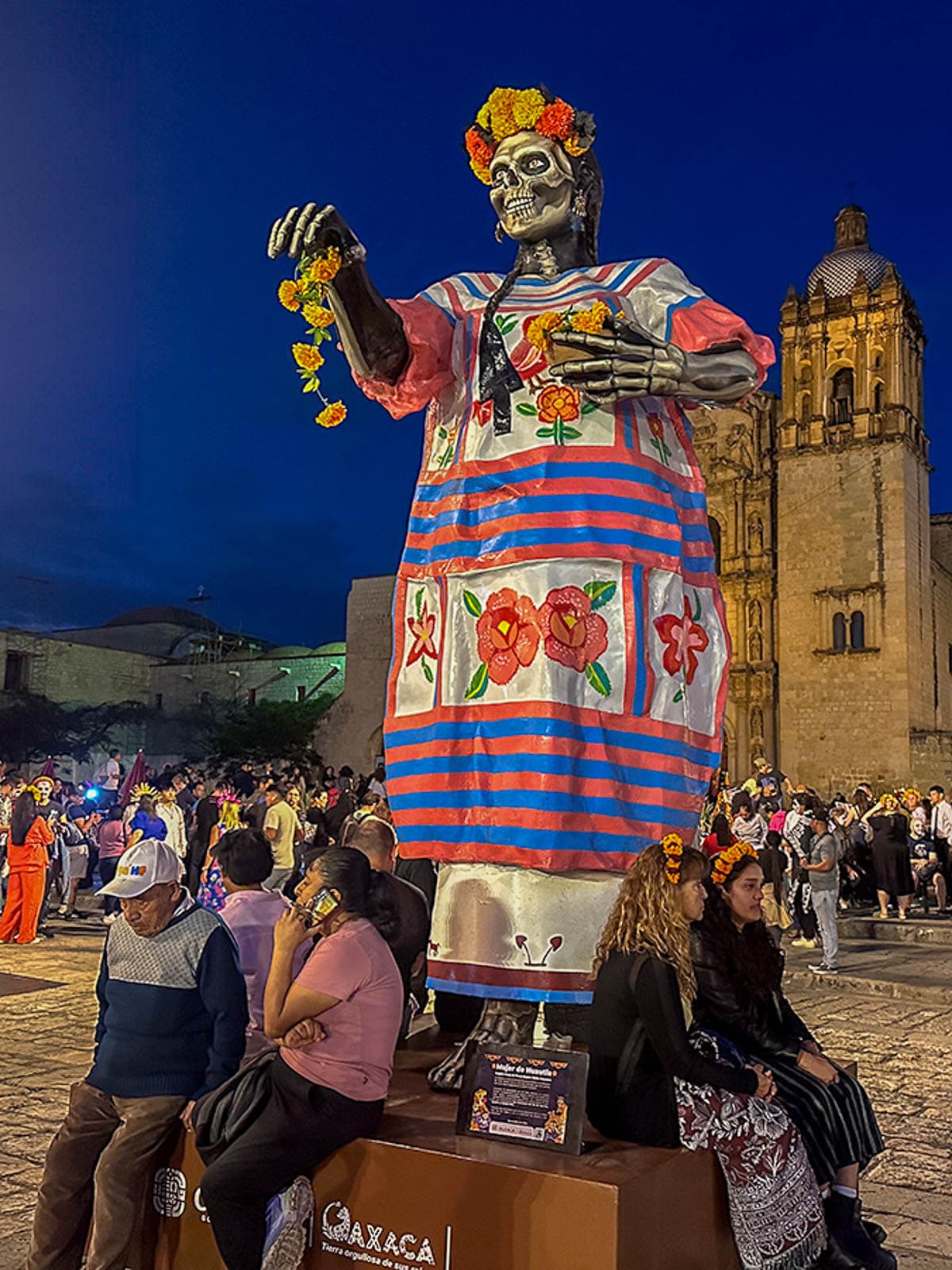 Statue of skeleton wearing traditional Mexican clothing in front of a cathedral during Day of the Dead in Oaxaca, Mexico