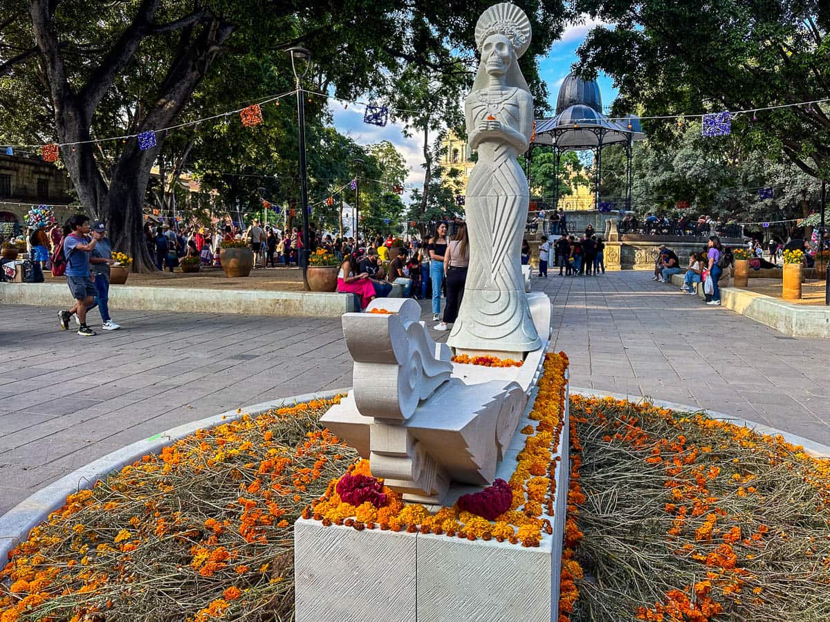 Statue of a skeleton surrounded by marigolds in Centro Historico in Oaxaca, Mexico