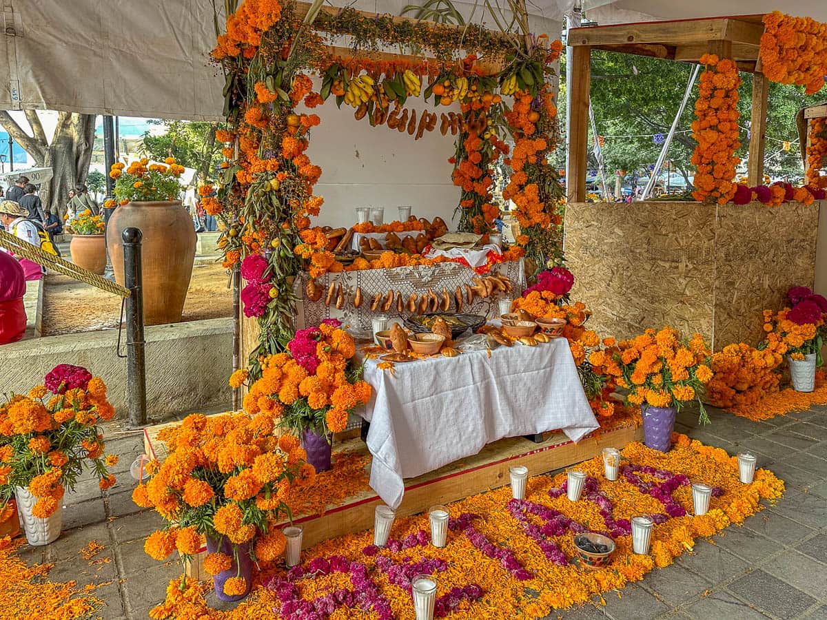 Offrenda with skulls, fruits, marigolds, and drinks on a table in Oaxaca, Mexico during Dia de Muertos
