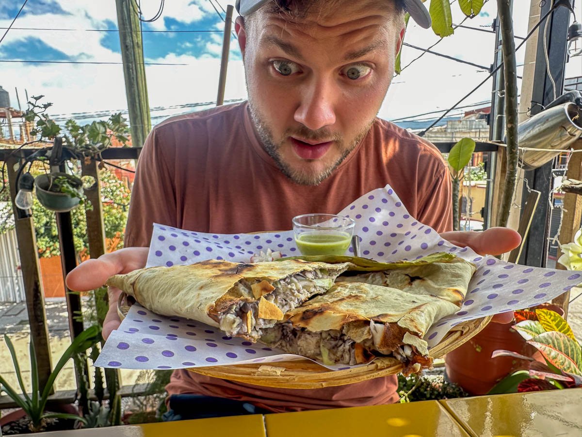 Man looking at a plate of Mexican food in Oaxaca, Mexico