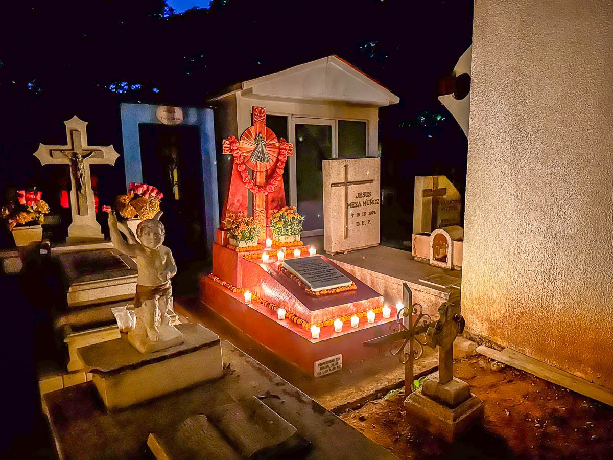 Grave decorated with candles and marigolds in Pantheon General during Dia de Muertos in Oaxaca, Mexico
