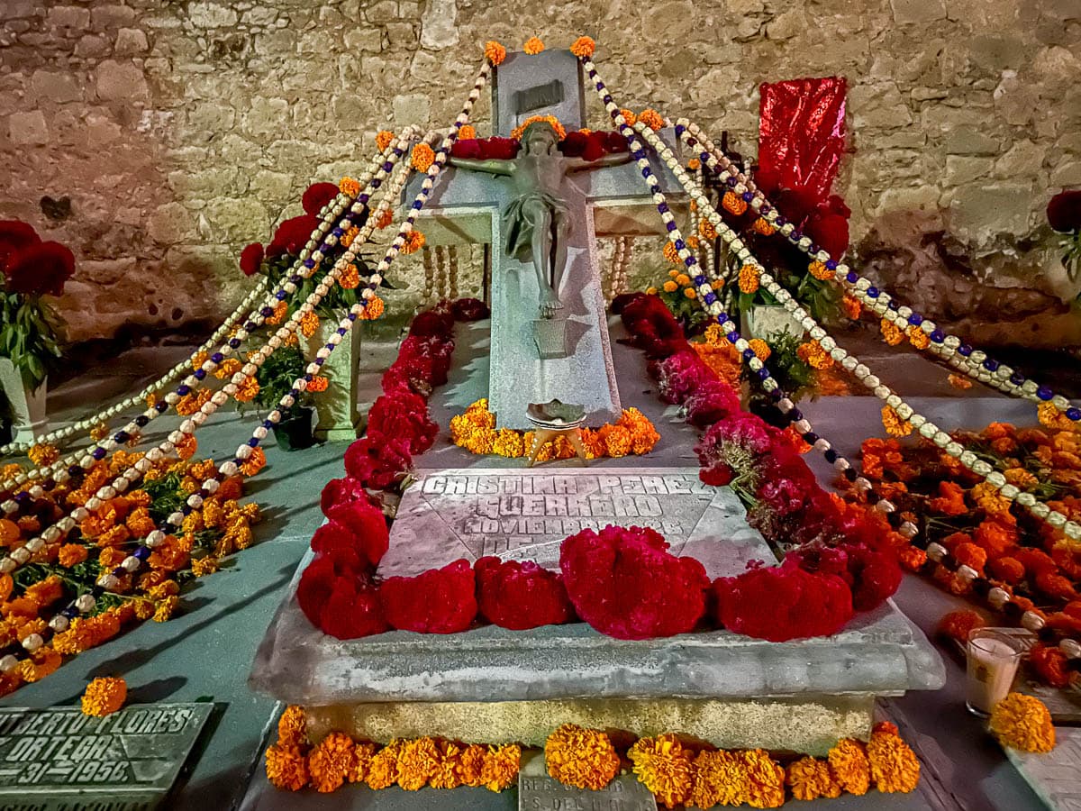 Grave decorated with beads, marigolds, and candles in Panteon General during Dia de Muertos in Oaxaca, Mexico