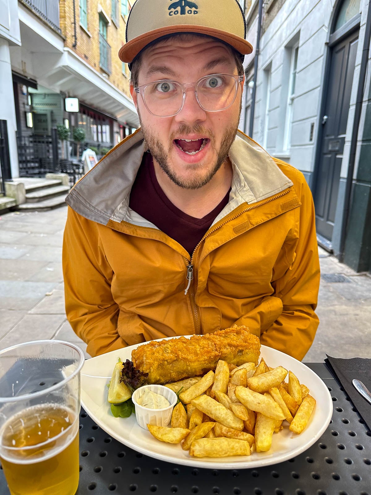 Man smiling in front of fish and chips in London, England