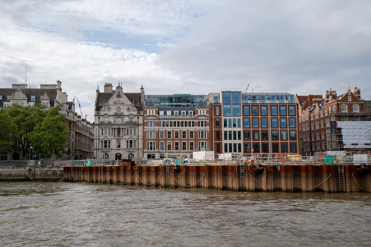 Historical buildings lining the Thames River from a scenic boat cruise in London, England