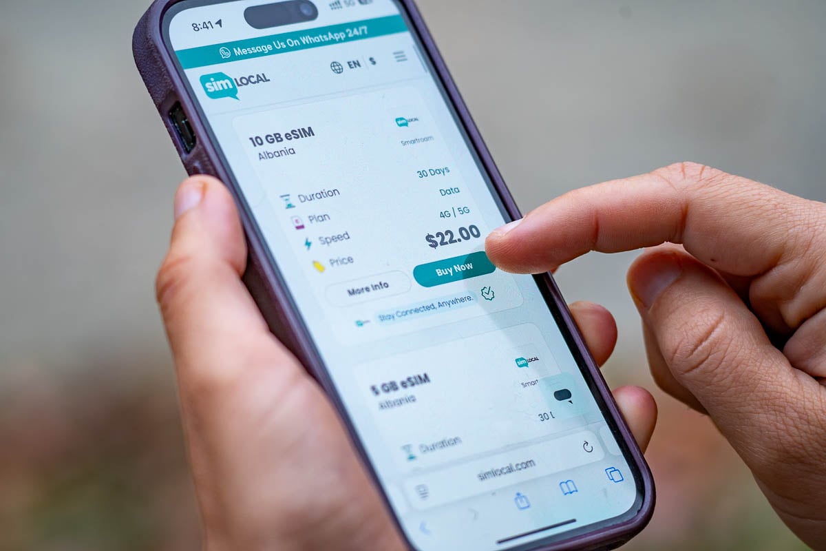 Woman looking at eSIM packages for Sim Local on a cell phone