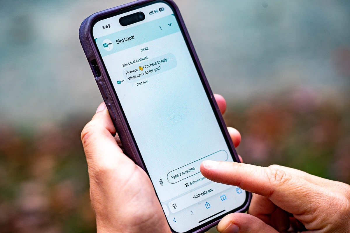 Woman touching her cell phone with a support chat on Sim Local, an eSIM provider