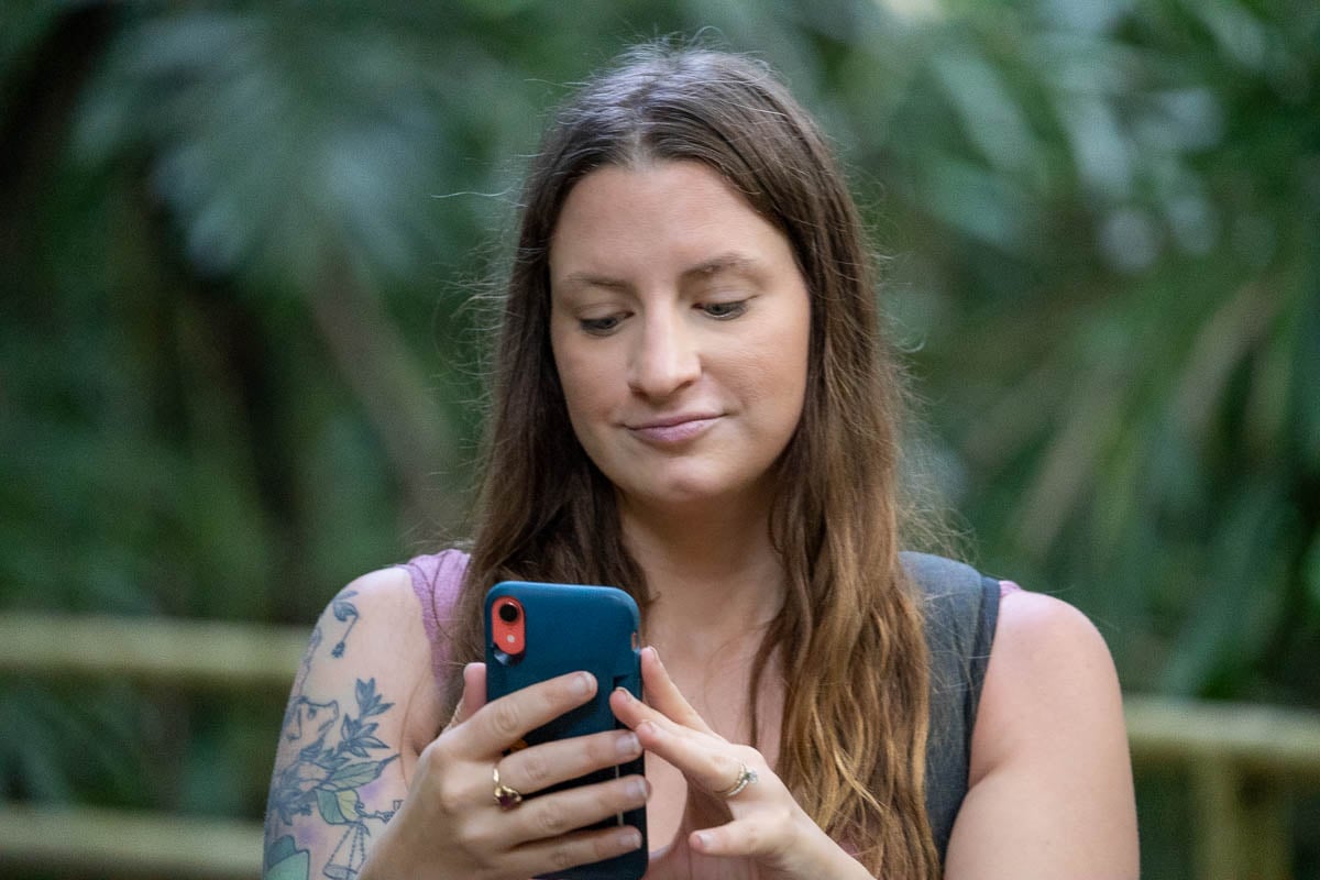 Woman looking at her cell phone on a hiking trail in Costa Rica